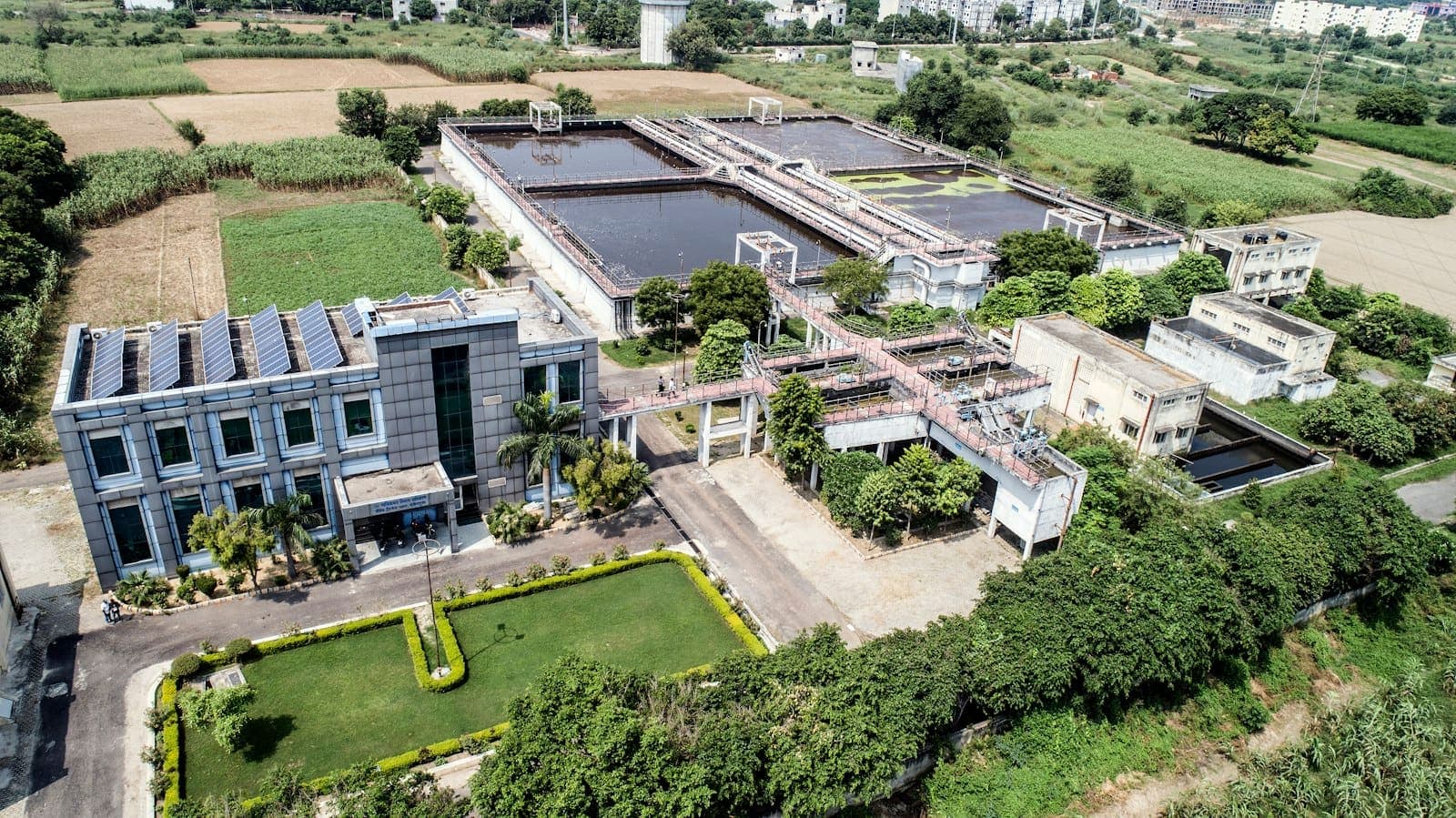 Vista aérea de uma estação de tratamento de água cercada por campos