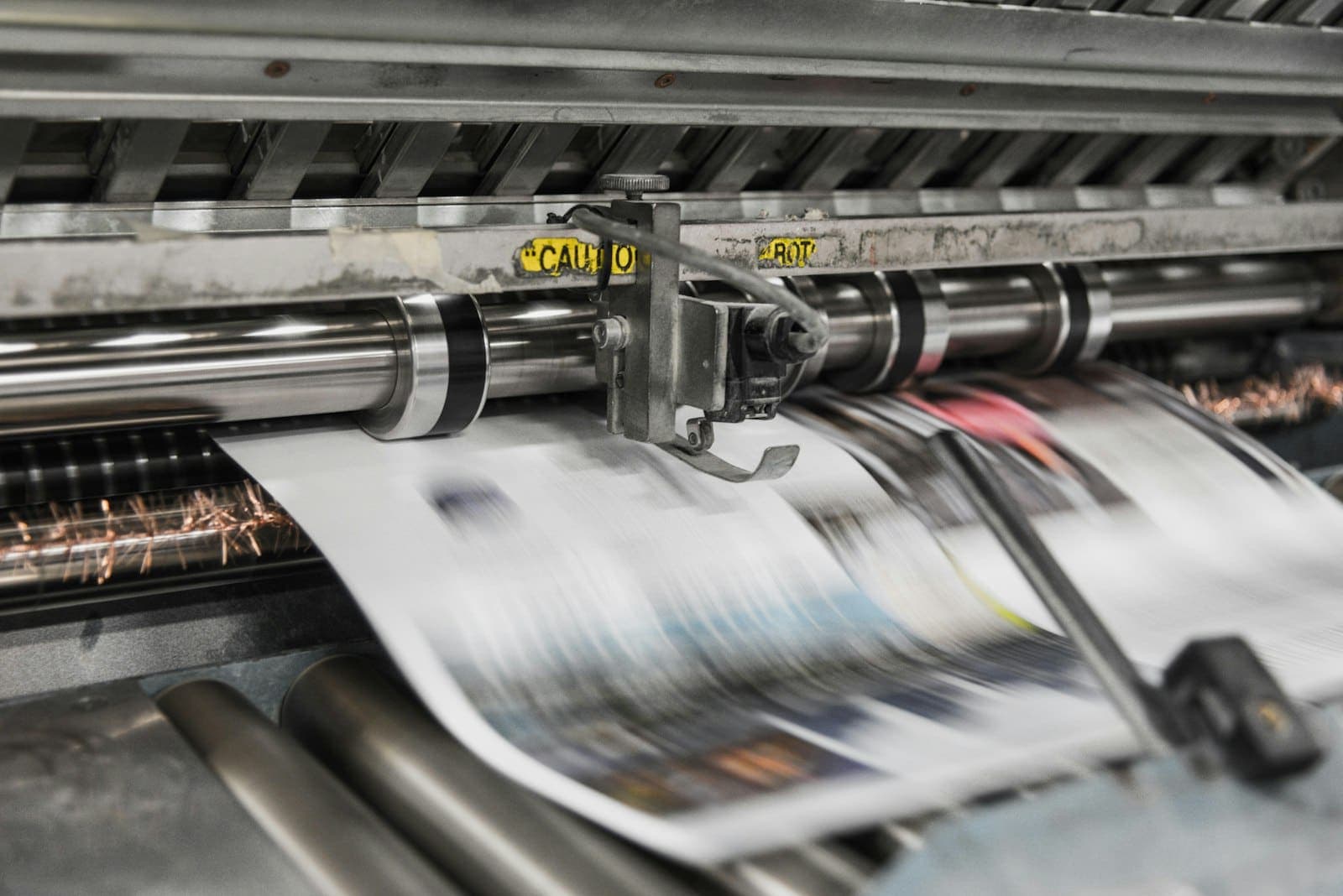 Rotativa imprimindo páginas de jornal em uma gráfica