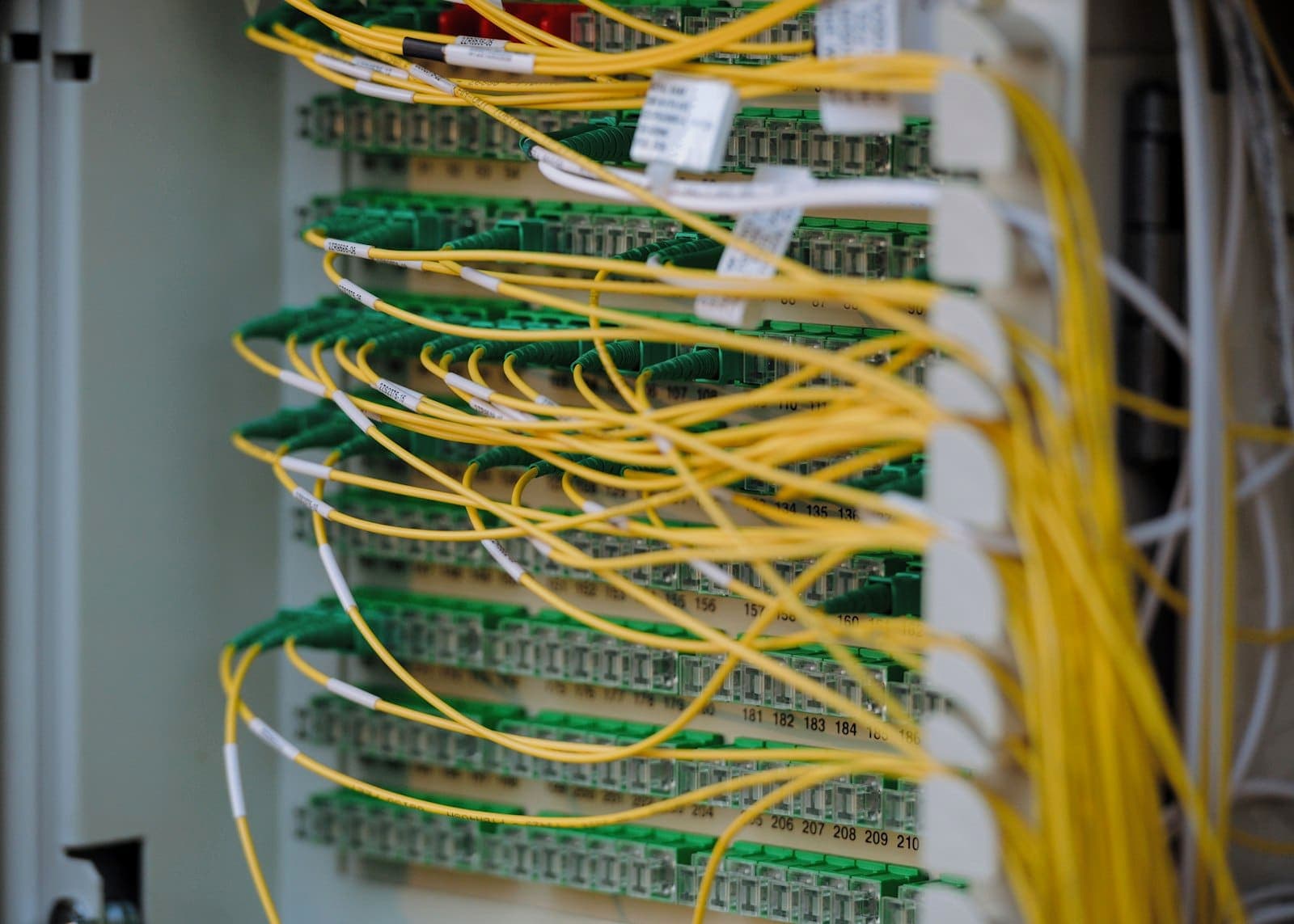 Cabos de fibra óptica amarelos conectados a painéis de rede