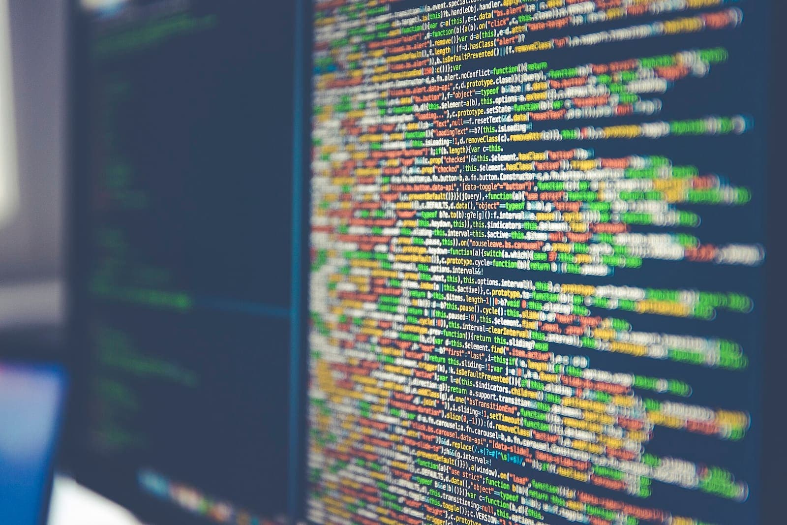 Tela de computador com linhas de código em várias cores, em um ambiente de desenvolvimento de software